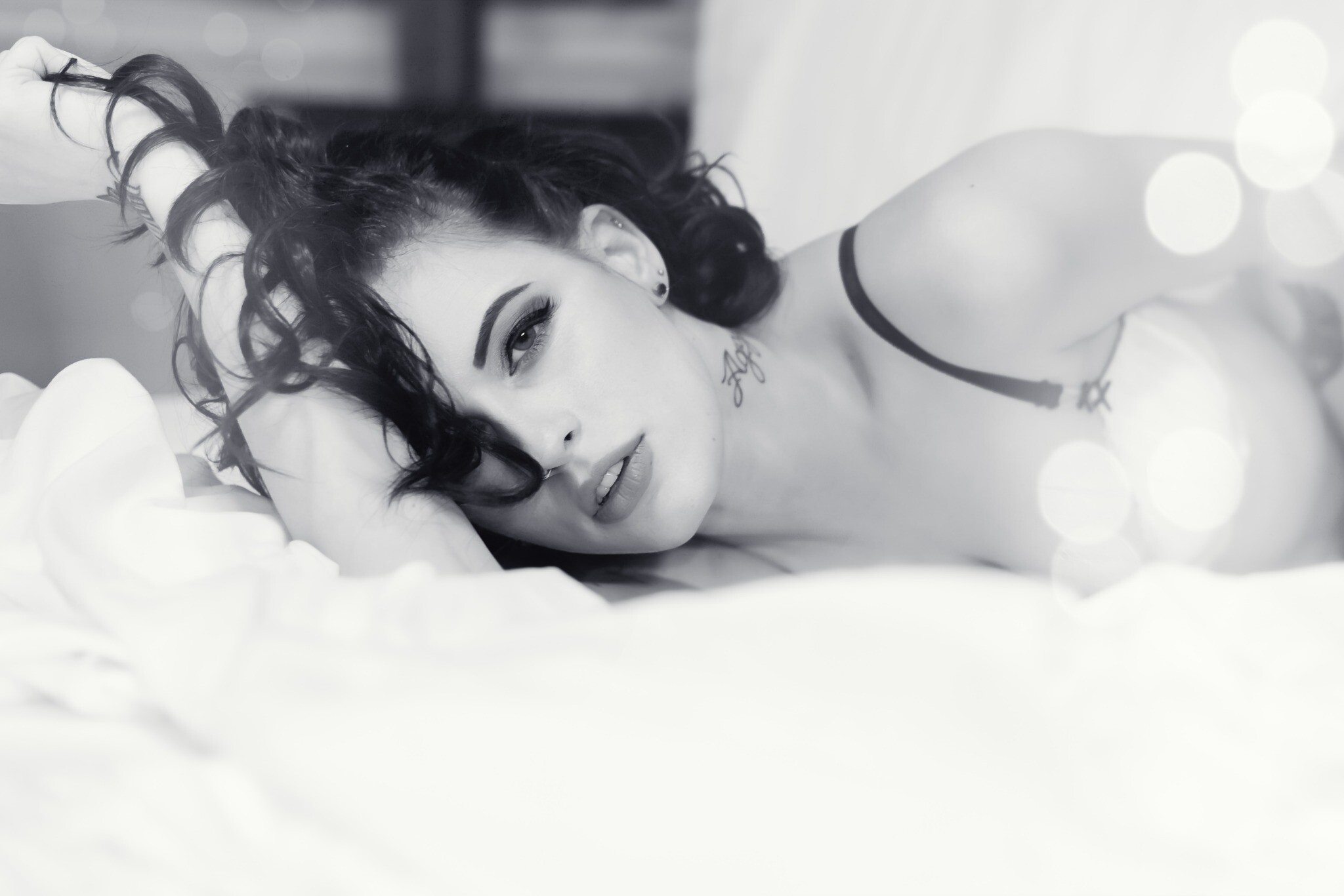 Black-and-white boudoir portrait of a woman reclining on a bed